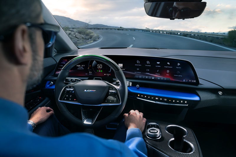 Front View of the 2026 OPTIQ-V Driving Through the Dusk Utilizing its Headlights | Lavery Cadillac in Alliance OH